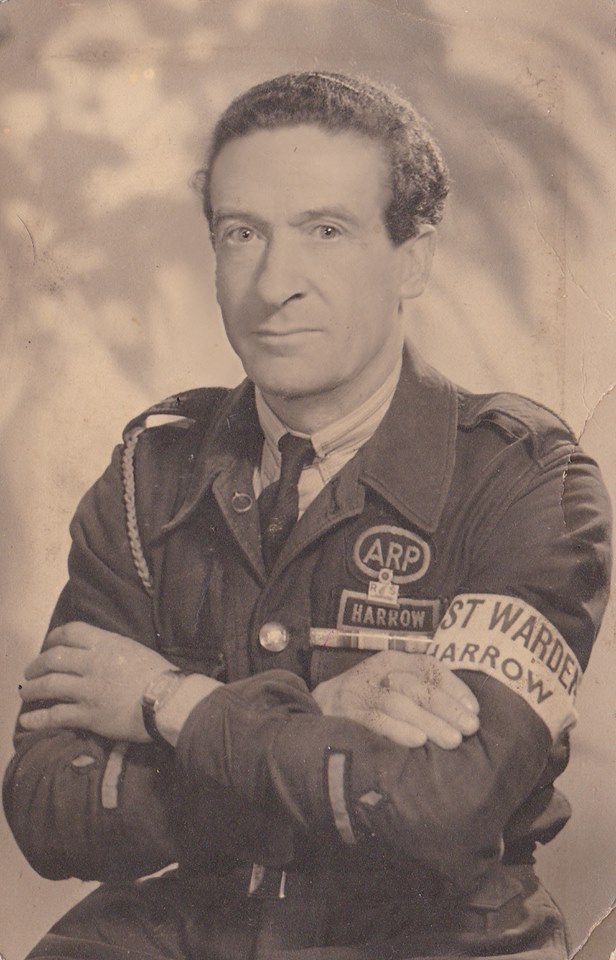 George Earl, an ARP Post Warden from Harrow. Wearing the bluette overalls with rank on sleeve, armband, first world war medal ribbon and enamel Royal Life Saving Respiration Badge. (Boddington)
