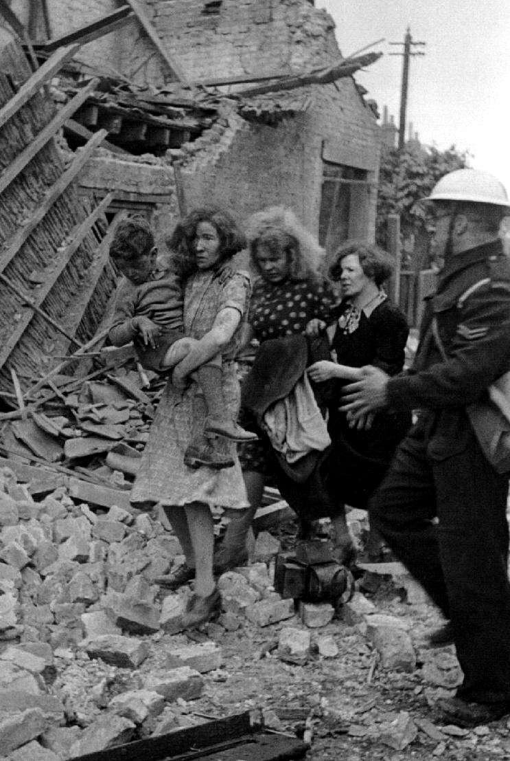 Survivors of a bombing raid are escorted by an ARP warden to safety.