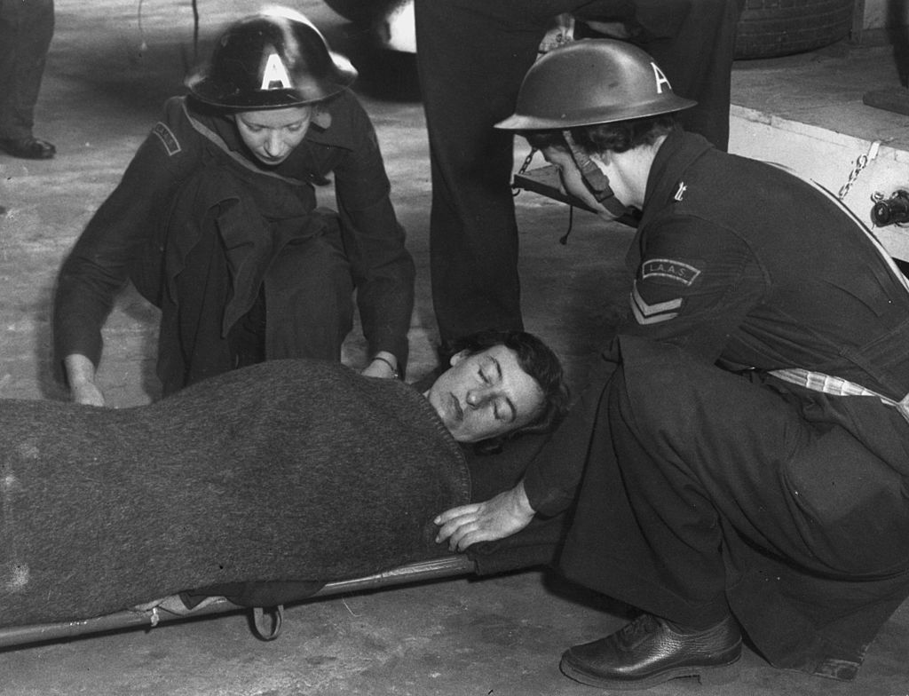 Two Members Of The London Auxiliary Ambulance Service Attend To A Patient