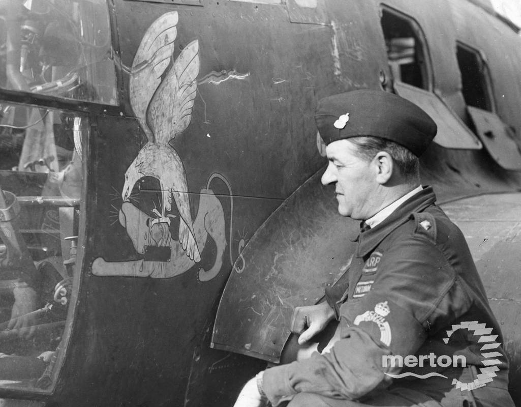 AN ARP warden from Mitcham inspects a downed German bomber.